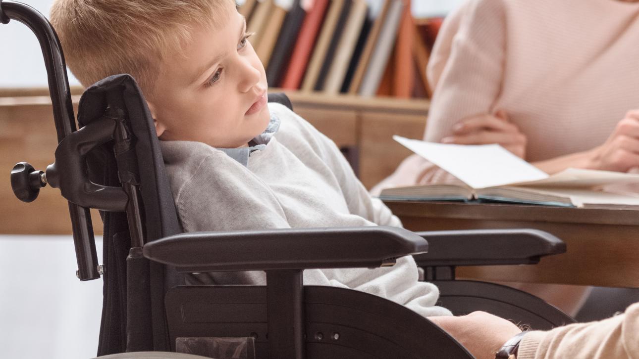 Petit garçon en fauteuil roulant avec un air triste