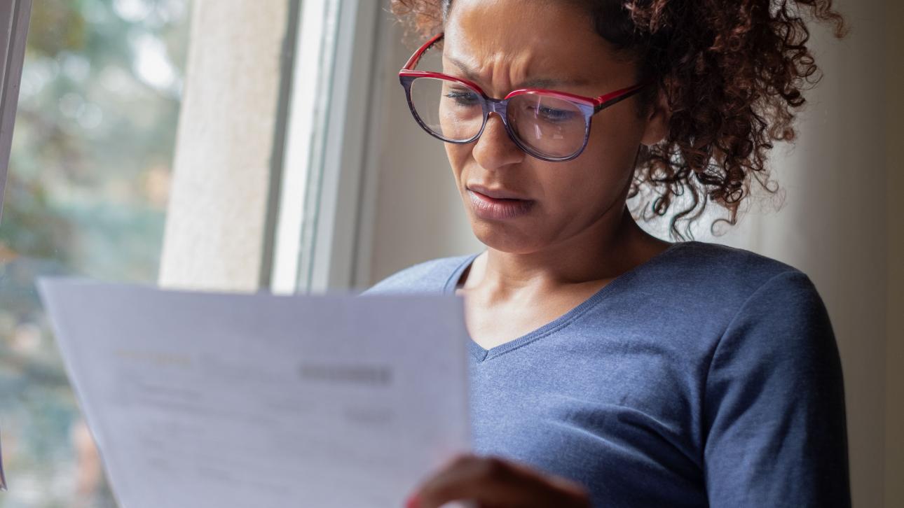 Femme lisant une lettre d'un air perplexe