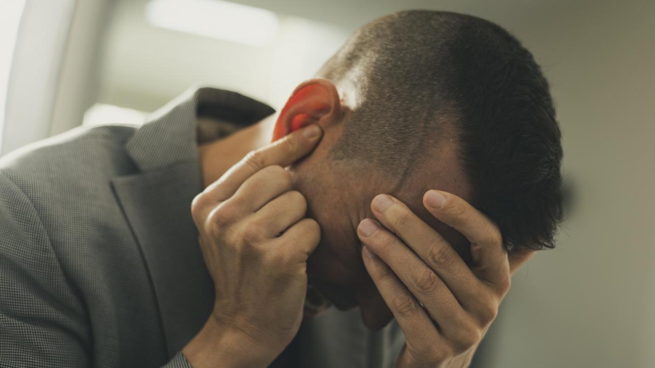 Un homme en crise se cache les yeux et se bouche une oreille