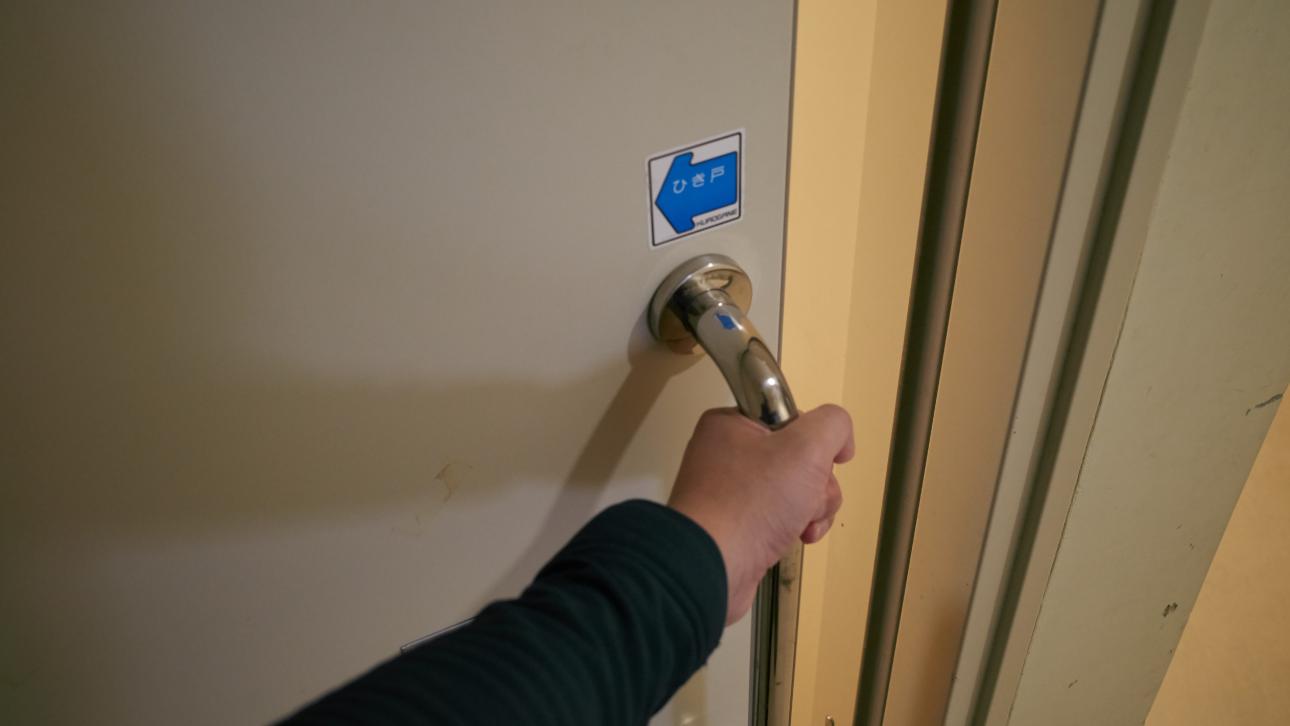 Main anonyme ouvrant une porte