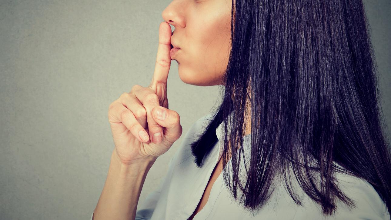 Femme faisant un signe de silence avec son doigt