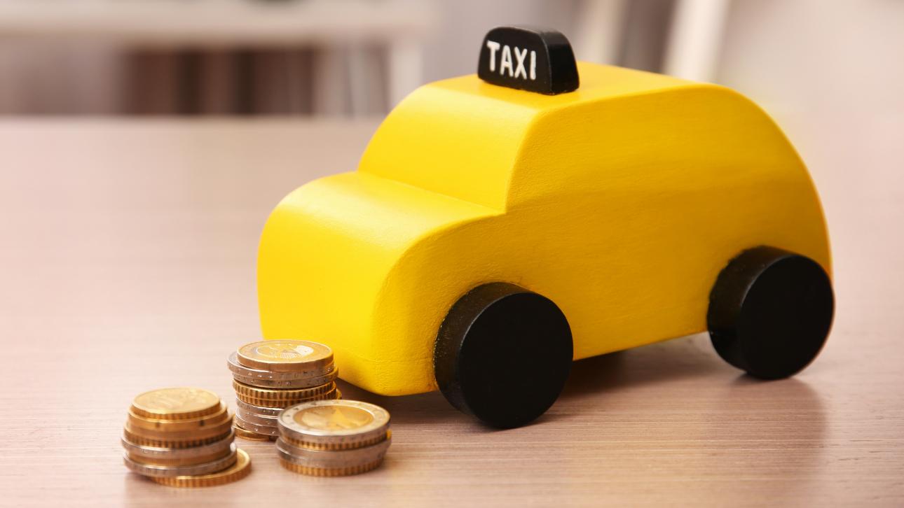 Pièces de monnaie placées près d'un jouet représentant un taxi