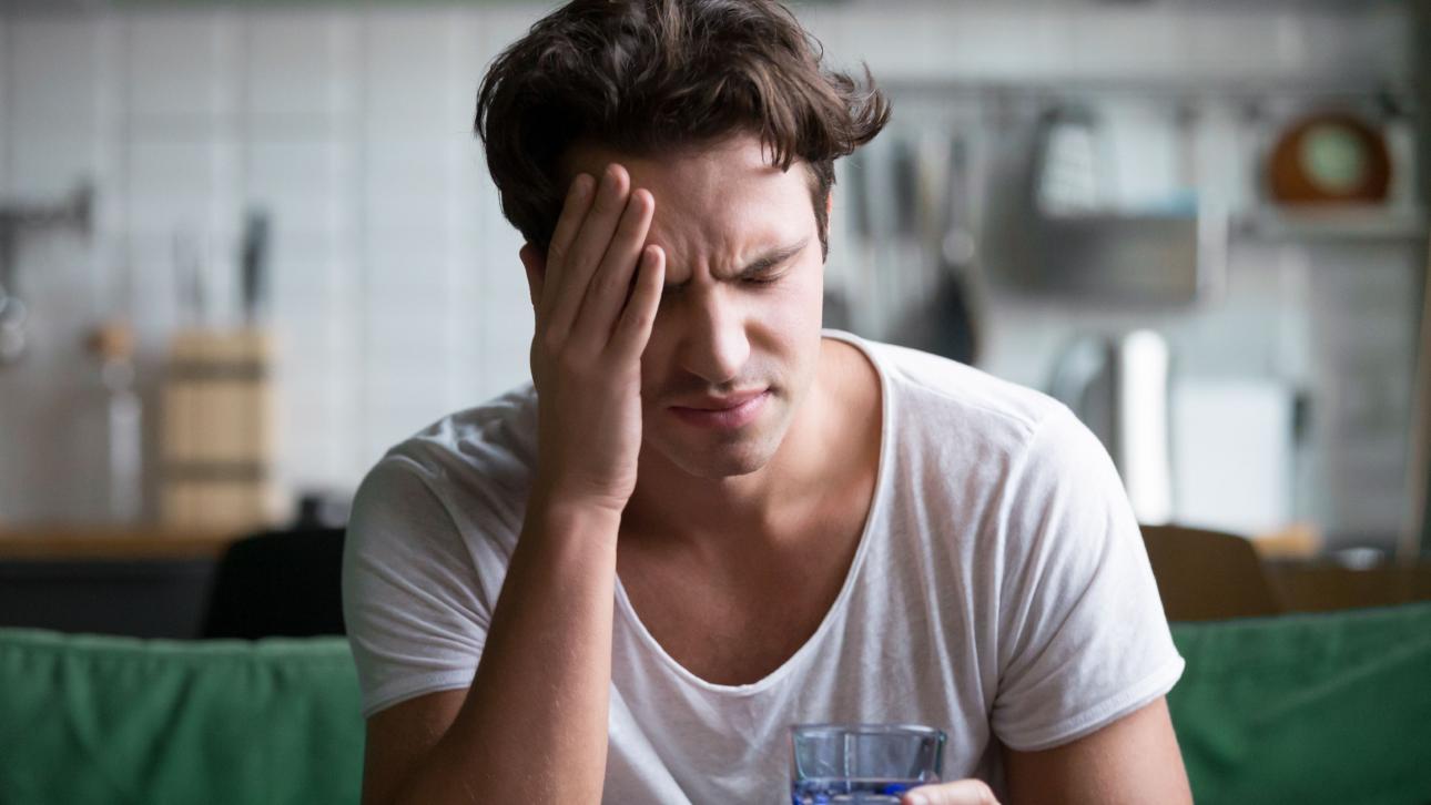 Jeune homme se touchant le front en raison d'un mal de tête