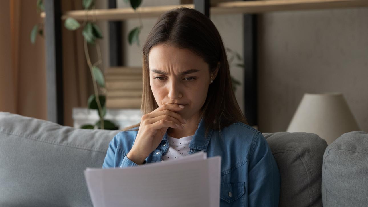 Femme regardant des papiers d'un air incertain