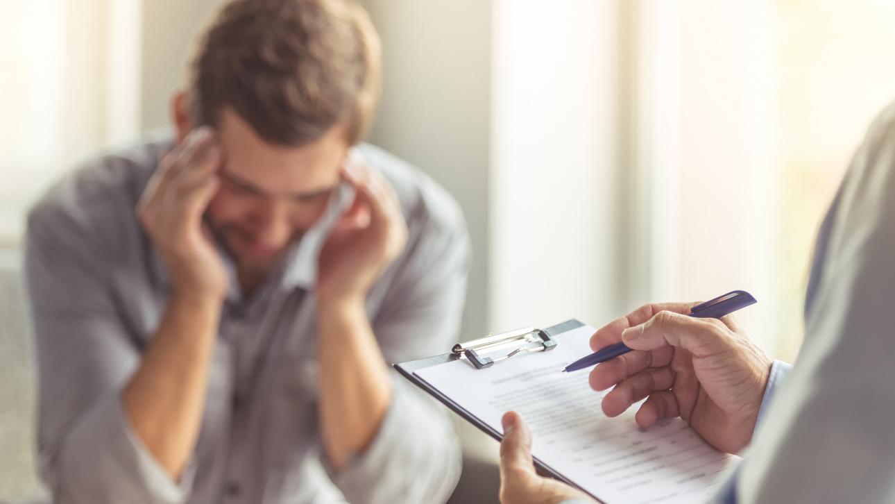 Homme assis devant son psychologue qui évalue son état