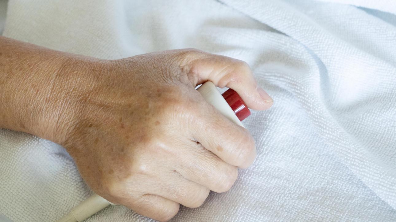 Hand holding a call bell