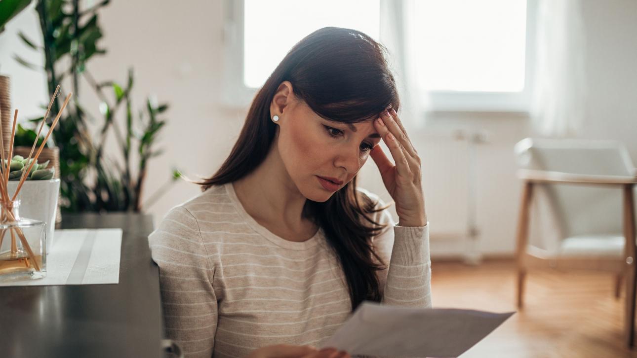 Une femme inquiète lit une lettre d'éviction de son logement