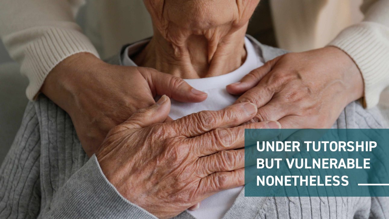 Hand of an elderly lady holding those of her guardian which are on her shoulders