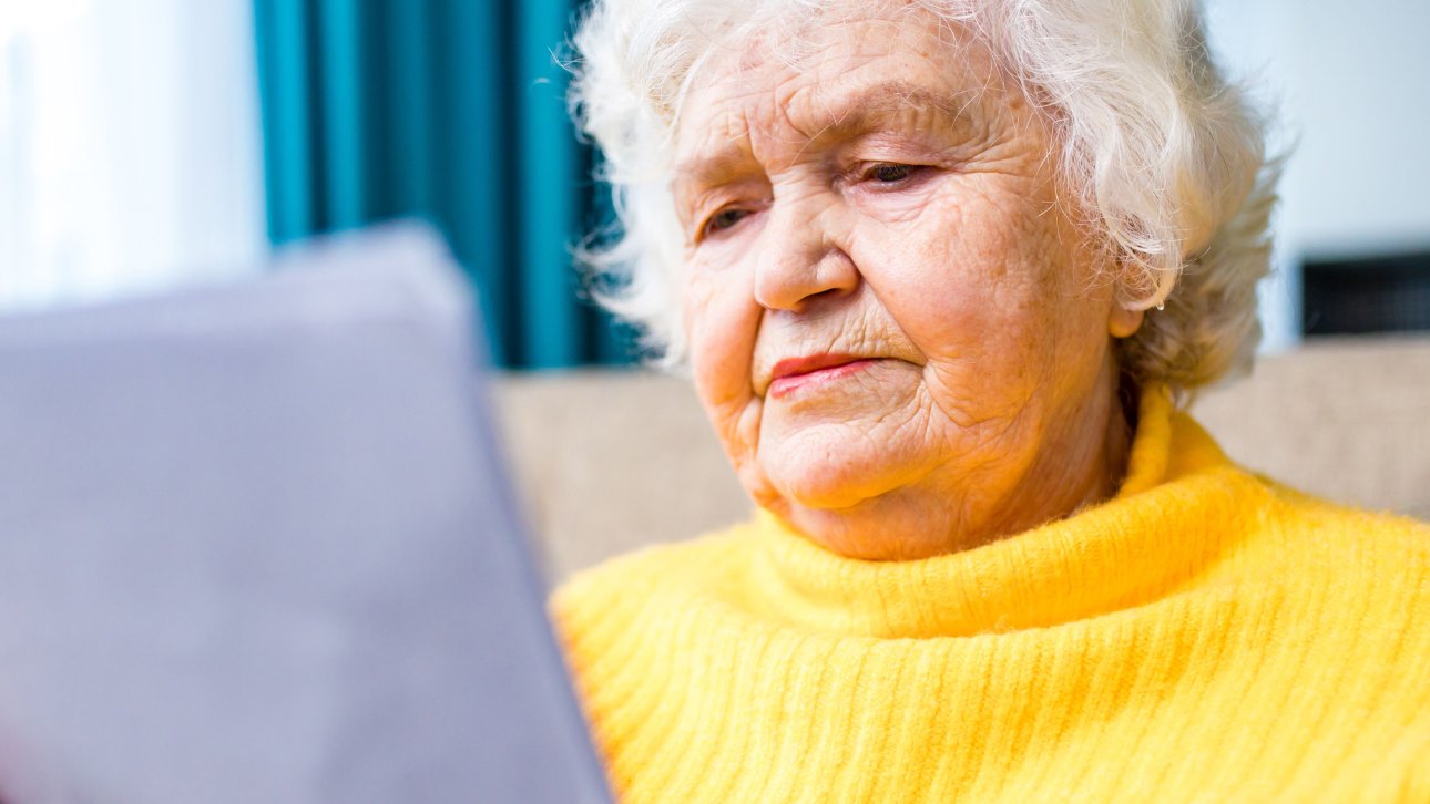 Elderly lady showing a worried look while reading a document