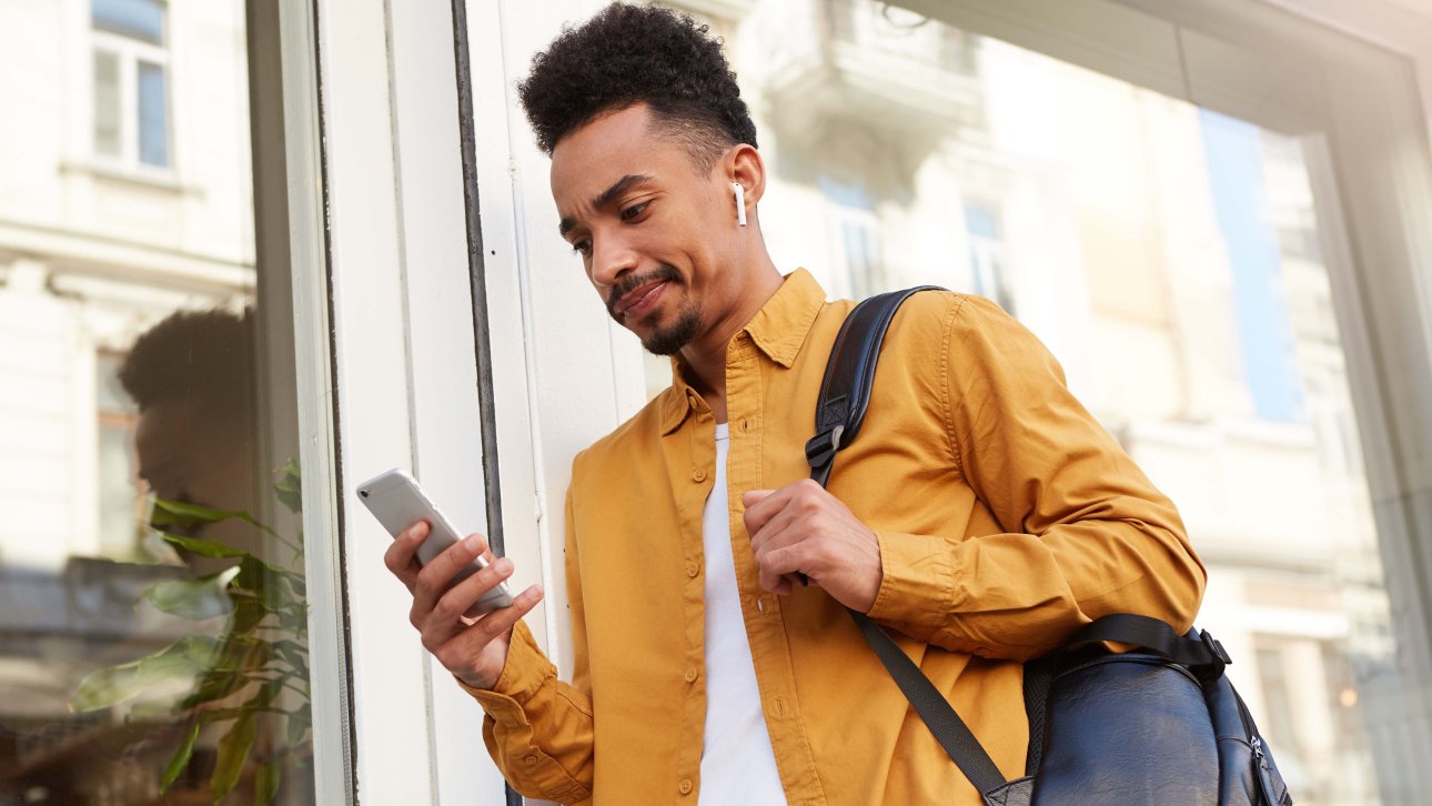 Étudiant regardant son cellulaire d'un air perplexe