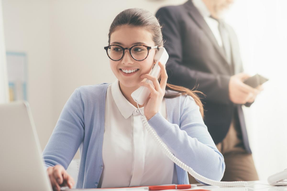 Jeune étudiante au travail et parlant au téléphone