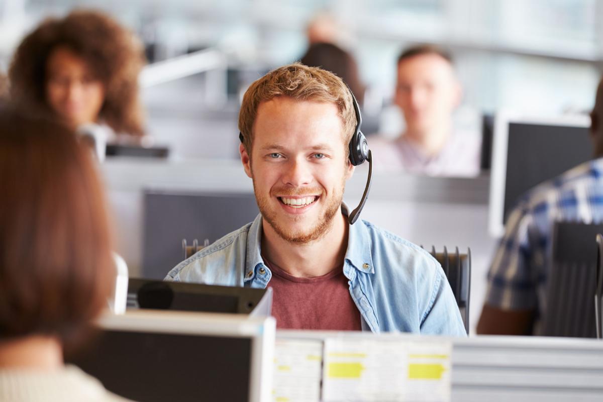 Agent à la recevabilité portant son micro-casque au bureau