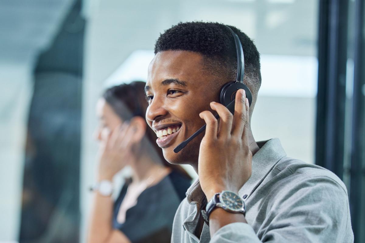 Étudiant souriant portant un casque d'écoute au travail