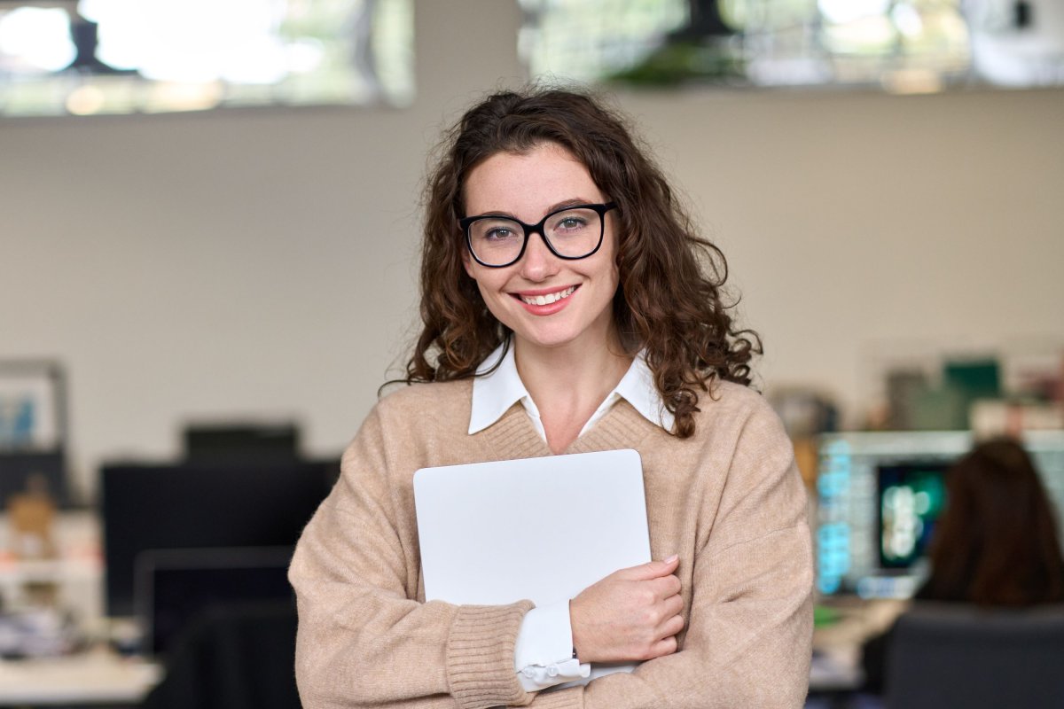 Stagiaire tenant un cahier de notes au bureau