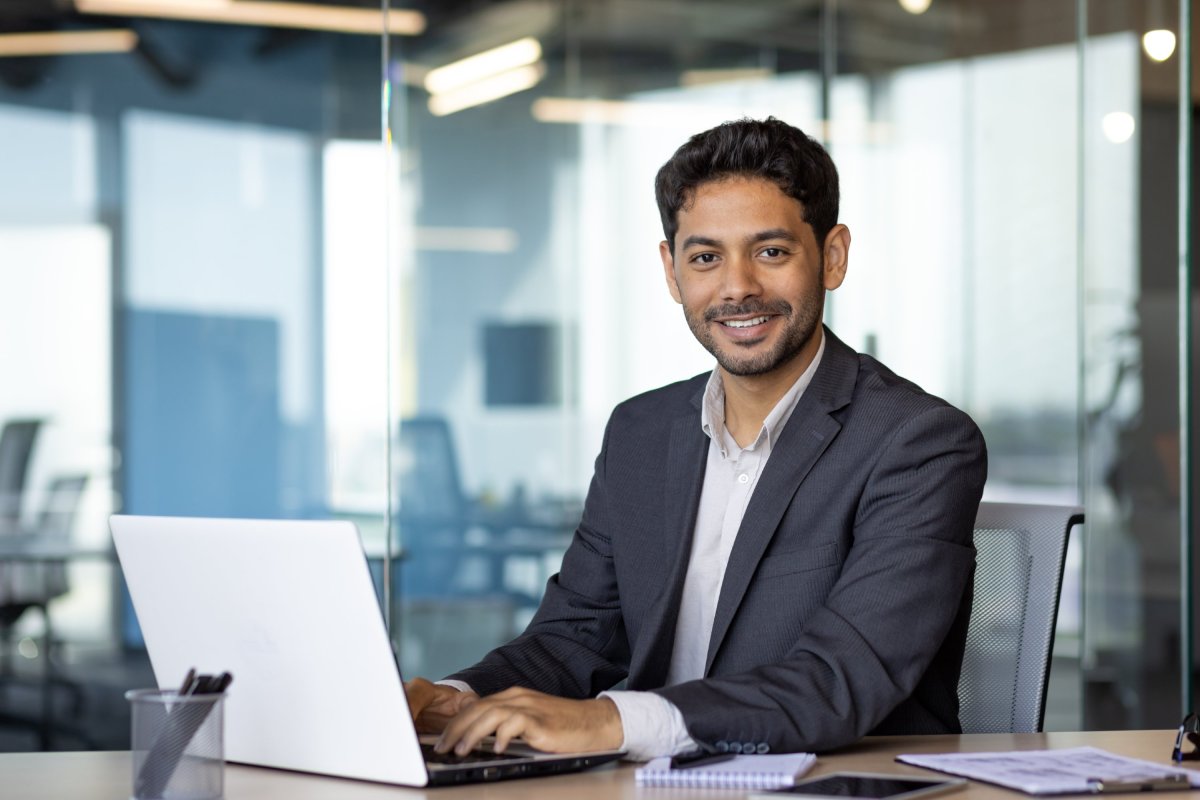 Enquêteur souriant travaillant sur son ordinateur portable au bureau