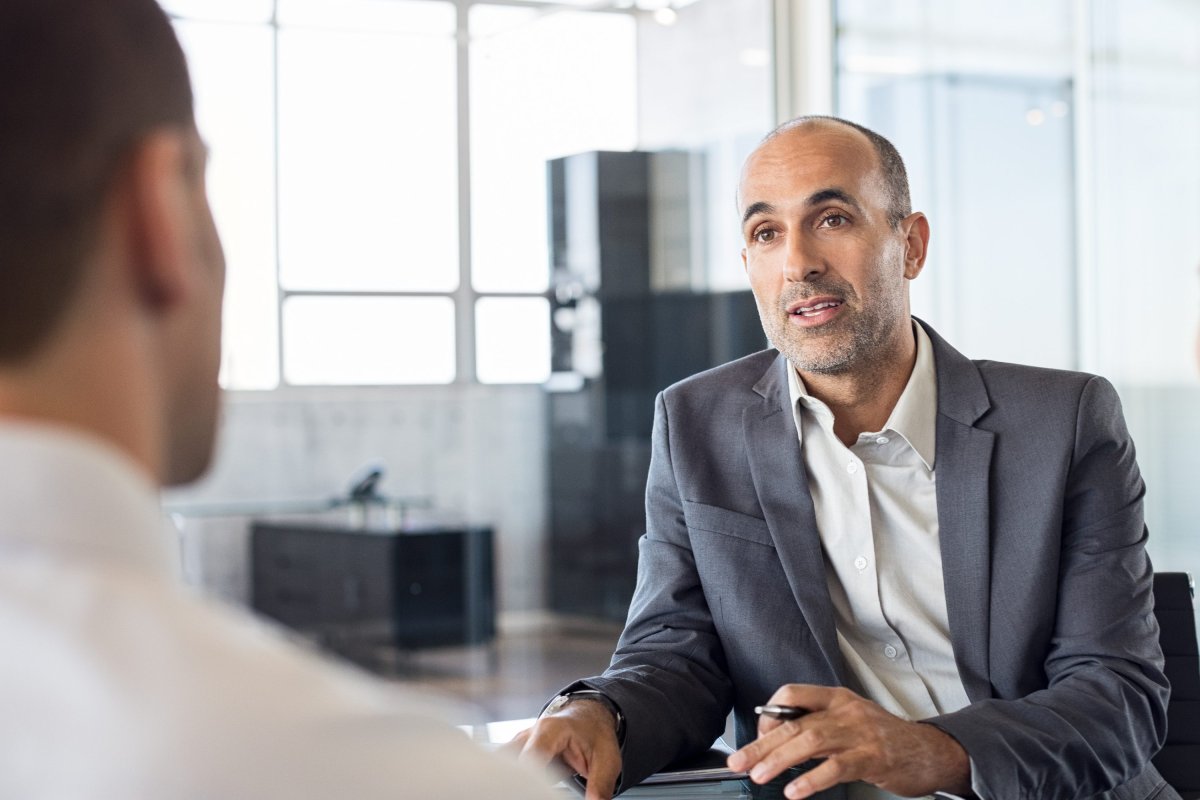 Homme mature à l'allure professionnelle discutant avec un collègue de bureau.