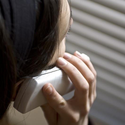 Gros plan d'une femme vue de dos qui parle au téléphone