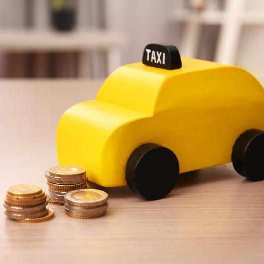 Pièces de monnaie placées près d'un jouet représentant un taxi