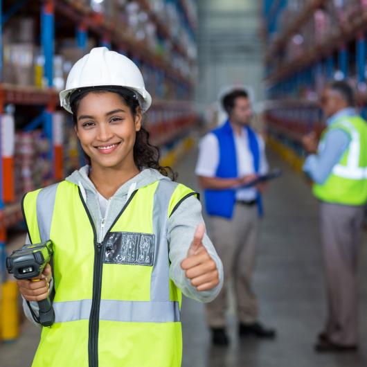 Jeune travailleuse portant un casque de sécurité dans un entrepôt