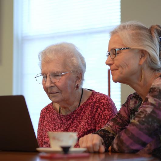 Une femme âgée et sa mère regardent un écran d'ordinateur