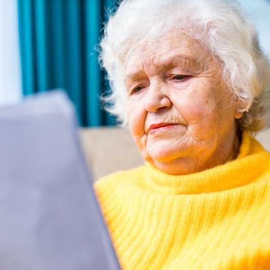 Elderly lady showing a worried look while reading a document