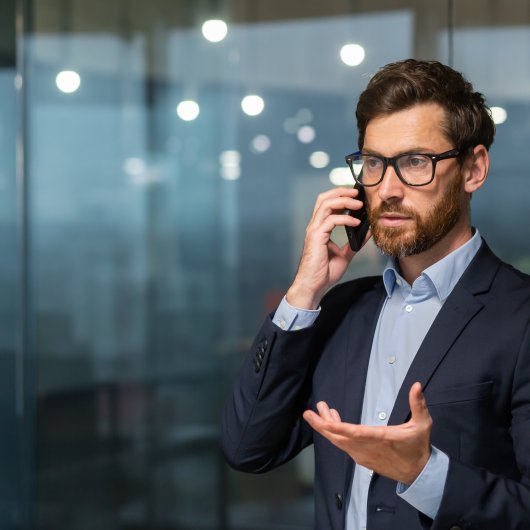 Un jeune homme argumentant au téléphone