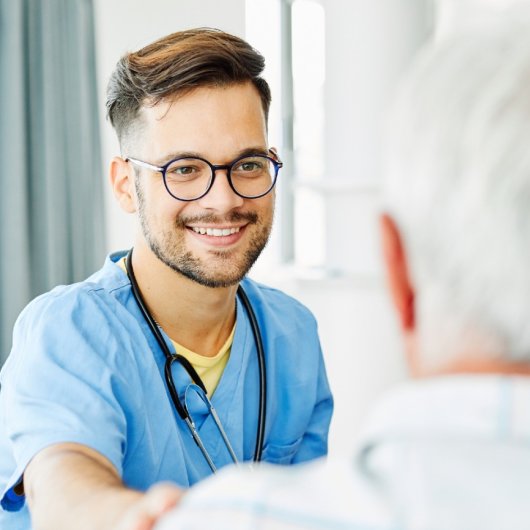 A nurse from the Health and Social Services network smiles at an elderly person.