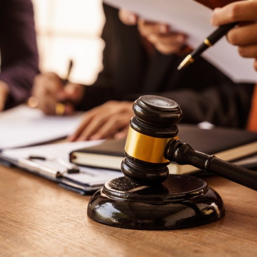 Avocats au travail derrière le maillet de la justice apparaissant au premier plan.
